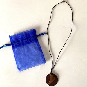 A Metal Circle Round Necklace With Blue Gift Bag Jewelry